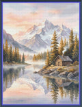 A scenic landscape artwork showing snow-capped mountains, evergreen trees, a calm lake with reflections, and a small log cabin on the shore. The scene is framed by a blue border.