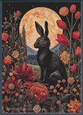 A  cross stitch design featuring a black rabbit sitting in front of a large glowing orange moon, surrounded by red and orange flowers on a dark background. The bottom edge shows the website watermark 'www.
