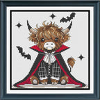 A framed cross-stitch artwork featuring a cute Highland cow dressed as a vampire, with brown fur, a black cape with red lining, white shirt details, and black bat silhouettes on a white stitched background.