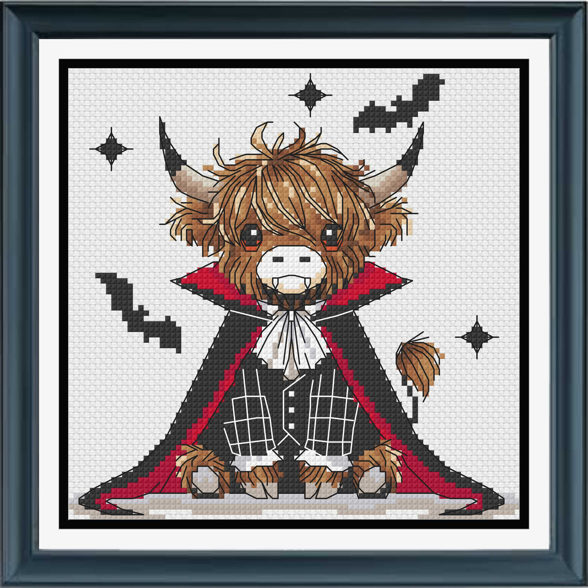 A framed cross-stitch artwork featuring a cute Highland cow dressed as a vampire, with brown fur, a black cape with red lining, white shirt details, and black bat silhouettes on a white stitched background.