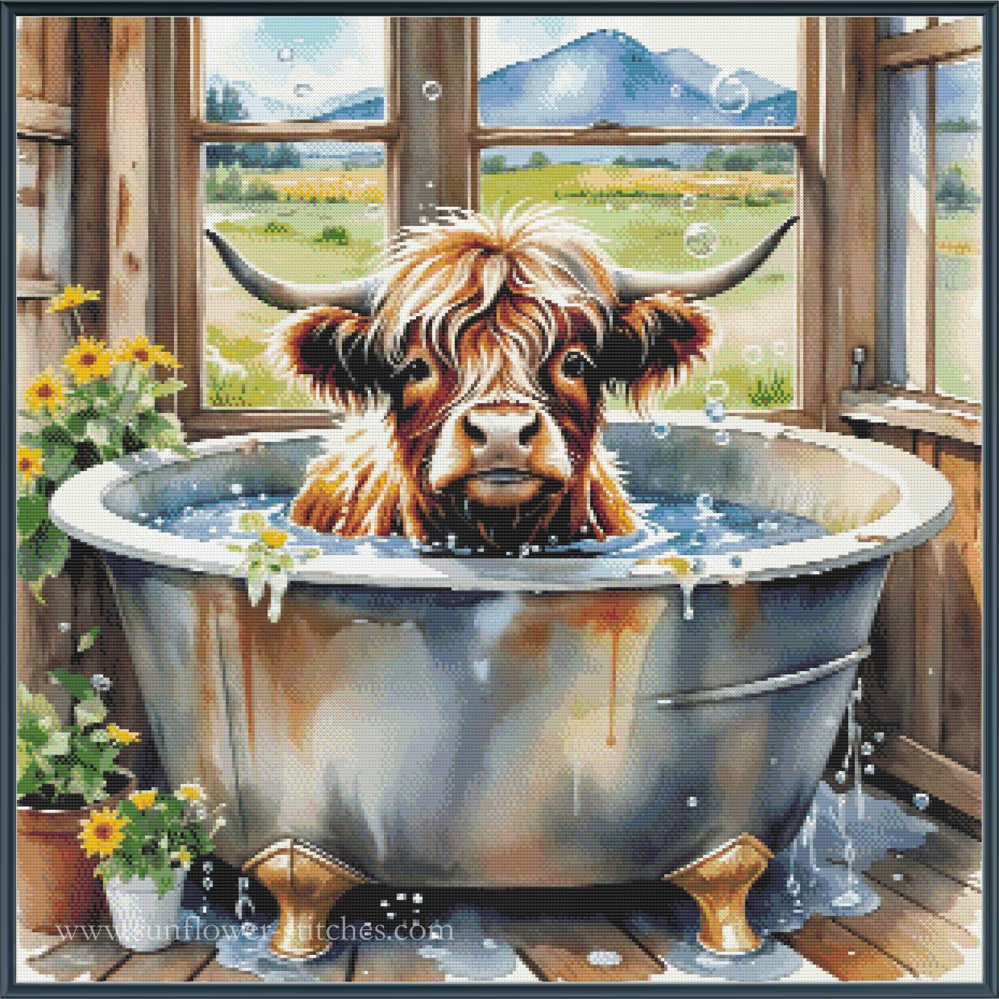 A square full coverage cross stitch depicting a highland cow with long horns sitting in a rusty metal clawfoot bathtub filled with water inside a rustic wooden cabin. Sunflowers, potted plants, and a scenic mountain landscape are visible through the windows in the background.