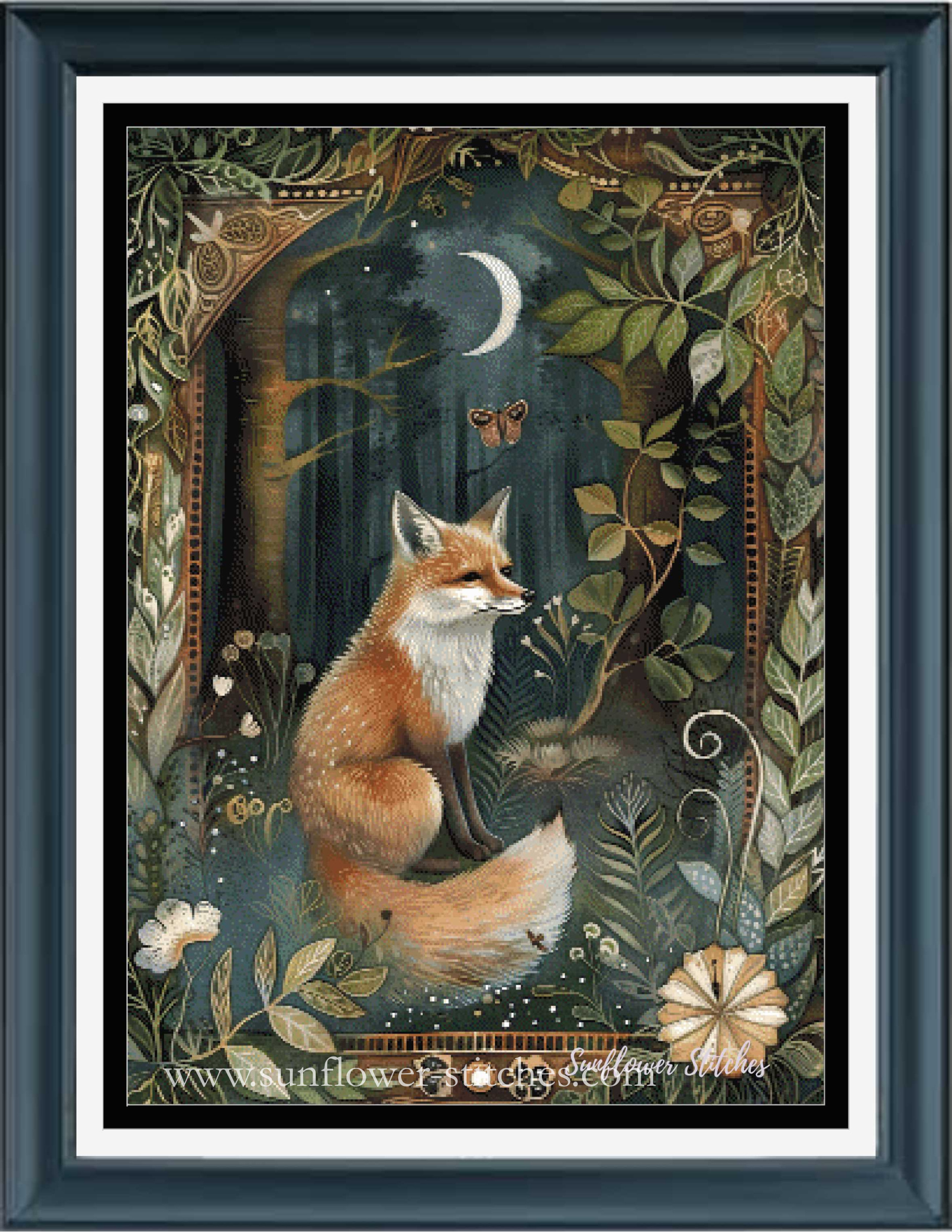 A framed fantasy cross stitch featuring an orange fox in a moonlit forest with a crescent moon, butterfly, and ornate floral border. The artwork is presented in a dark blue frame with a white mat.