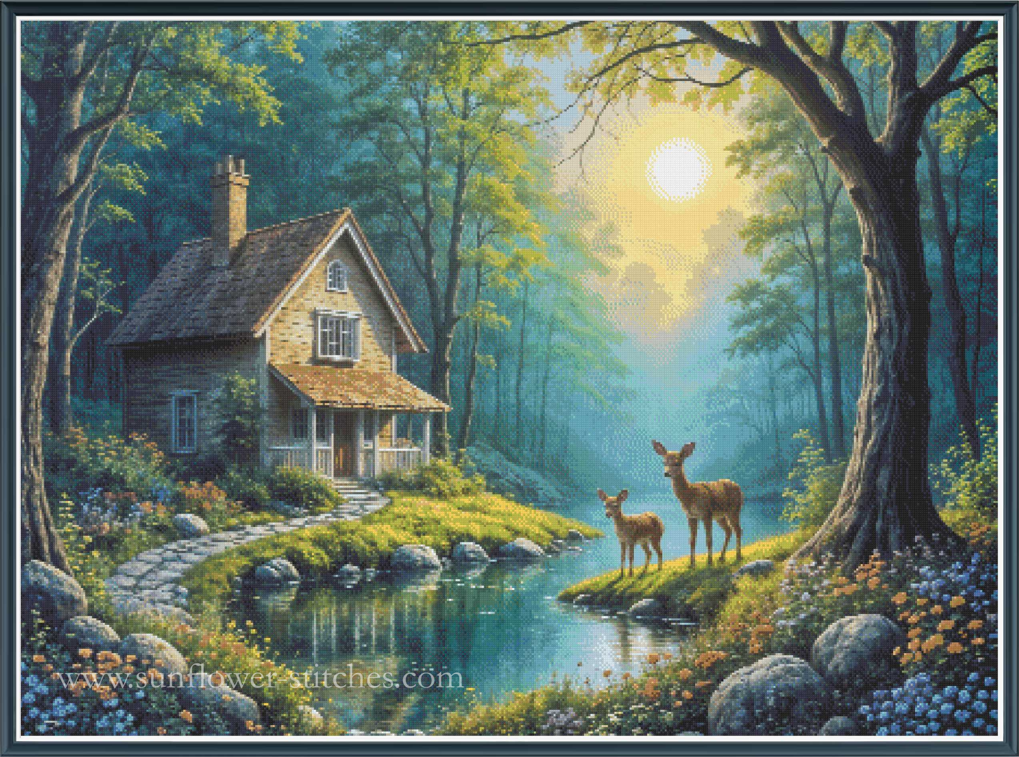 A full coverage cross stitch woodland scene with a small rustic house beside a calm stream, two deer standing on the bank, and a bright sun filtering through tall trees. 
